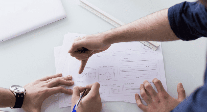 duas pessoas desenhando em papel de desenho industrial para patente de modelo de utilidade