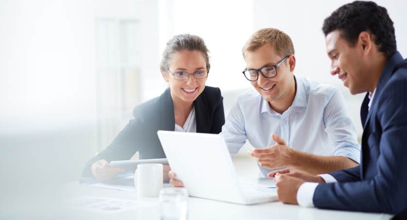 Equipe de três especialistas em propriedade intelectual na frente de um laptop